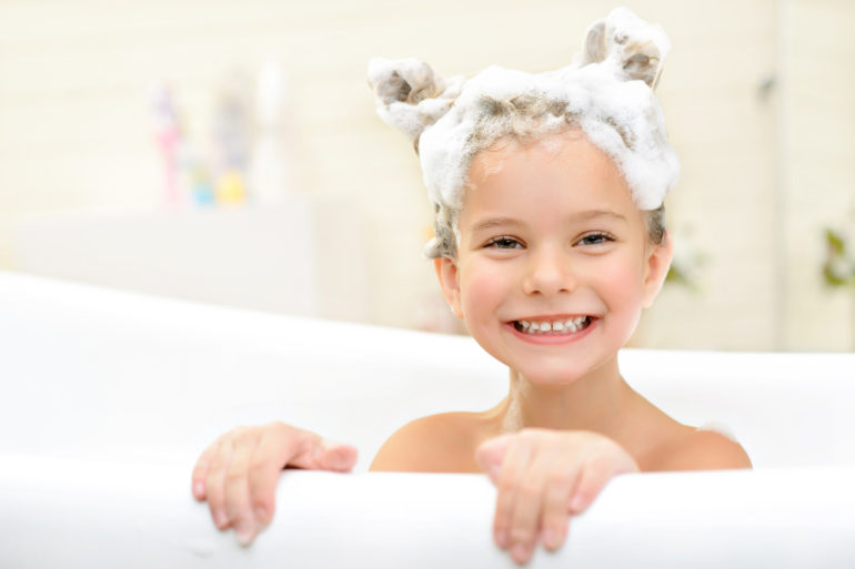 Une petite fille soigne ses poux naturellement dans son bain